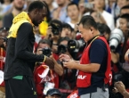 Bolt sa smiješkom prihvatio dar od kamermana koji mu je 'uklizao' tijekom slavlja